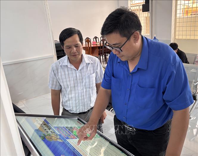 Chính quyền địa phương xã Phú Hựu hỗ trợ doanh nghiệp thực hiện các thủ tục hành chính trên cổng dịch vụ công. Ảnh: Hồng Nhung - TTXVN