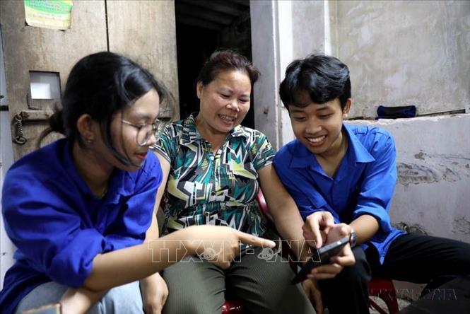 Đoàn Thanh niên xã Vũ Tiên (tỉnh Hưng Yên) hướng dẫn người dân cách sử dụng điện thoại thông minh để thực hiện các dịch vụ công trực tuyến và nhận diện các chiêu trò lừa đảo trên không gian mạng. Ảnh: Thế Duyệt-TTXVN