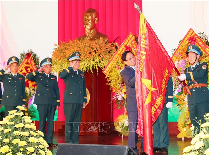 Thủ tướng Phạm Minh Chính gắn Danh hiệu Anh hùng LLVT nhân dân lên Quân kỳ Quyết thắng của Quân chủng PKKQ. Ảnh: Trọng Đức - TTXVN