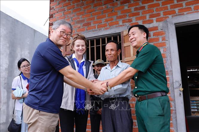 Đại diện Trung tâm Hành động bom mìn quốc gia Việt Nam (VNMAC) cùng bà Caitlin Wiesen, Đại diện thường trú Chương trình phát triển Liên hợp quốc tại Việt Nam (UNDP) tại Việt Nam và ông Cho Han Deog, Giám đốc Cơ quan hợp tác quốc tế Hàn Quốc tại Việt Nam (KOICA Vietnam) thăm người dân ở khu vực đã xử lý bom mìn, vật nổ tại xã Cát Nhơn, huyện Phù Cát, Bình ĐỊnh (20/10/2020). Ảnh: Dương Giang - TTXVN