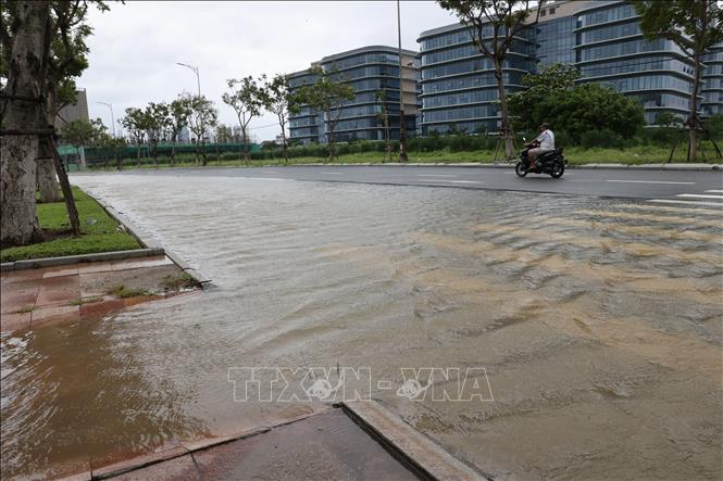 Nước sông Hàn tràn qua kè và lan ra lòng đường Như Nguyệt, gây ngập cục bộ. Ảnh: Anh Dũng - TTXVN