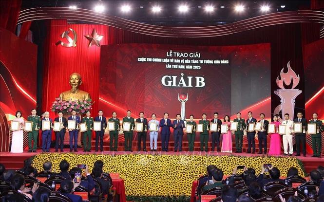 Đồng chí Nguyễn Xuân Thắng, Ủy viên Bộ Chính trị, Giám đốc Học viện Chính trị quốc gia Hồ Chí Minh, Chủ tịch Hội đồng Lý luận Trung ương, Phó Trưởng Ban Chỉ đạo 35 Trung ương, Trưởng Ban Chỉ đạo Cuộc thi và đồng chí Nguyễn Trọng Nghĩa, Ủy viên Bộ Chính trị, Bí thư Trung ương Đảng, Trưởng Ban Tuyên giáo và Dân vận Trung ương, Phó Trưởng Ban Chỉ đạo 35 Trung ương, Phó Trưởng Ban Chỉ đạo Cuộc thi trao giải B cho tác giả và nhóm tác giả đoạt giải. Ảnh: Văn Điệp – TTXVN