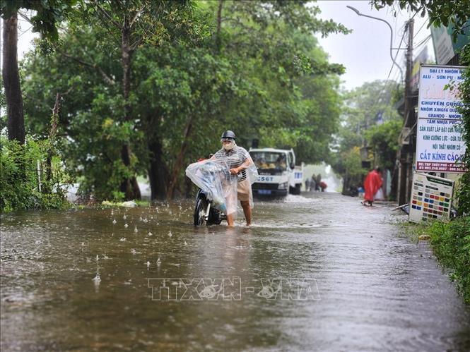 Xe chết máy khi đi qua đoạn đường nước sâu. Ảnh: Mai Trang- TTXVN 