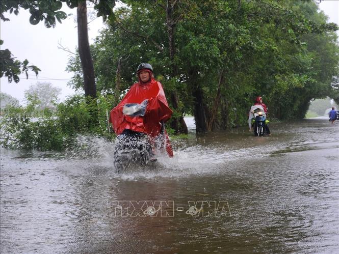 Xe cộ đi lại khó khăn qua vùng nước ngập sâu. Ảnh: Mai Trang- TTXVN 
