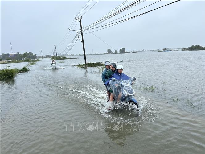 Xe máy đi lại khó khăn qua vùng nước ngập sâu. Ảnh: Mai Trang- TTXVN 