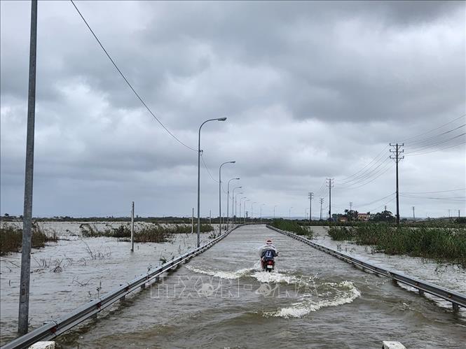 Xe máy đi lại khó khăn qua vùng nước ngập sâu. Ảnh: Mai Trang- TTXVN 