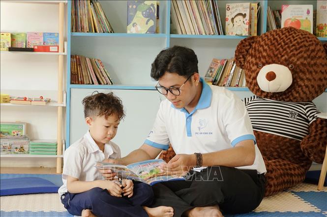 Anh Thạch Ngọc Hải đọc sách cùng trẻ em tại “Phòng học cho em” của chương trình thiện nguyện. Ảnh: TTXVN phát