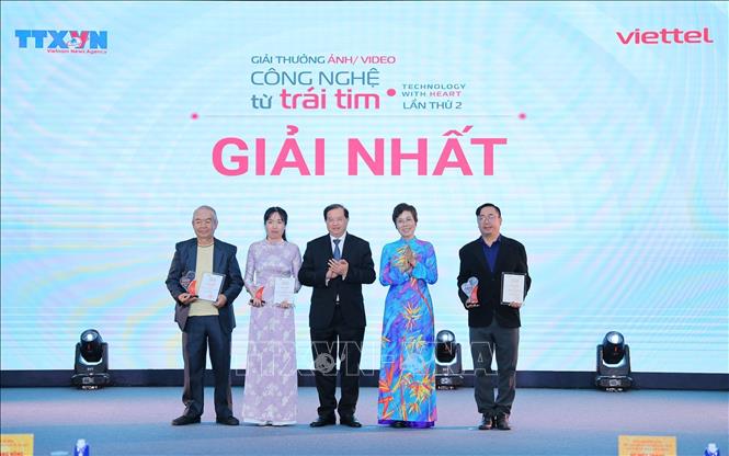 Tổng Giám đốc TTXVN Vũ Việt Trang, Chủ tịch Hội đồng Giải thưởng và Thứ trưởng Bộ Văn hóa, Thể thao và Du lịch Tạ Quang Đông trao giải Nhất cho các tác giả. Ảnh: Lê Đông - TTXVN