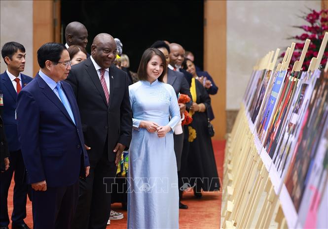 Thủ tướng Phạm Minh Chính và Tổng thống Nam Phi Matamela Cyril Ramaphosa xem trưng bày ảnh về quan hệ hợp tác giữa hai nước, do Thông tấn xã Việt Nam thực hiện. Ảnh: Dương Giang- TTXVN