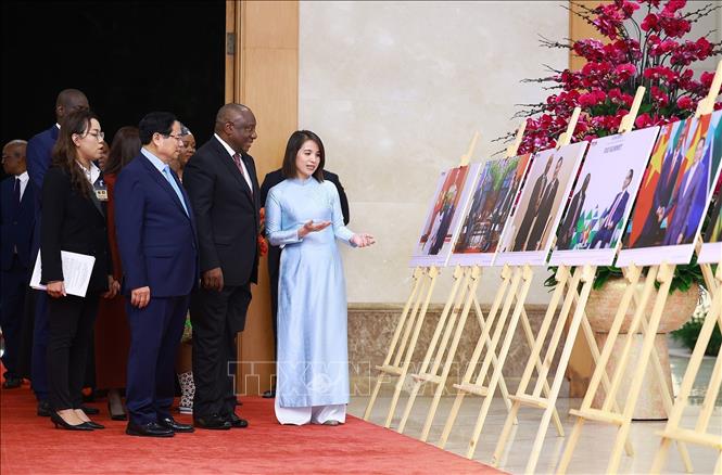 Thủ tướng Phạm Minh Chính và Tổng thống Nam Phi Matamela Cyril Ramaphosa xem trưng bày ảnh về quan hệ hợp tác giữa hai nước, do Thông tấn xã Việt Nam thực hiện. Ảnh: Dương Giang- TTXVN