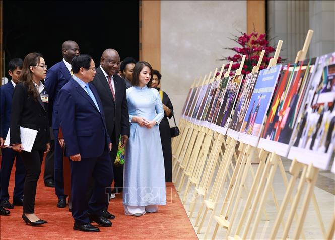 Thủ tướng Phạm Minh Chính và Tổng thống Nam Phi Matamela Cyril Ramaphosa xem trưng bày ảnh về quan hệ hợp tác giữa hai nước, do Thông tấn xã Việt Nam thực hiện. Ảnh: Dương Giang- TTXVN