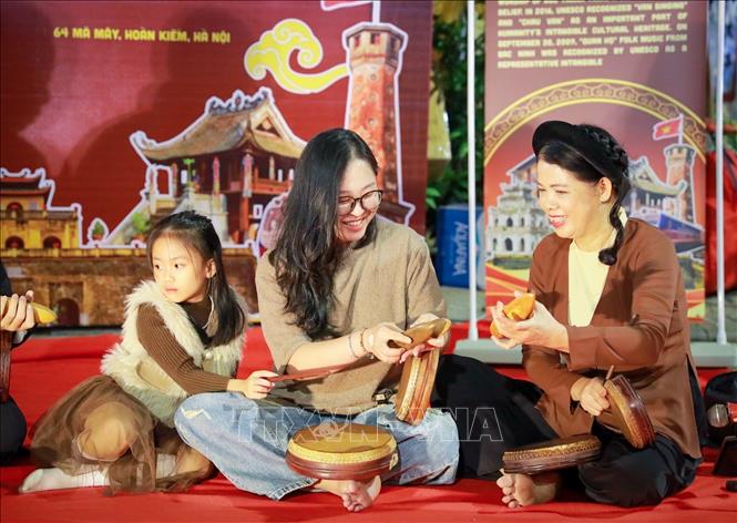 Nghệ sĩ giới thiệu các nhạc cụ của nghệ thuật truyền thống tới người dân và du khách. Ảnh: Khánh Hoà - TTXVN
