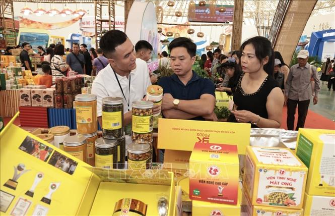 Du khách mua sắm sản phẩm trà hoa vàng đến từ Quảng Ninh. Ảnh: Trần Việt - TTXVN