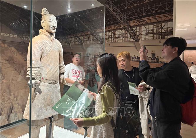 Du khách tìm hiểu về tượng Binh Mã Dõng của Tần Thủy Hoàng trưng bày tại bảo tàng Thường Thục, Tô Châu (Trung Quốc). Ảnh: Công Tuyên - PV TTXVN tại Trung Quốc