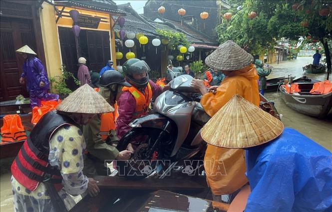  Lực lượng bộ đội thành phố Đà Nẵng giúp người dân ngập lụt phường Hội An di chuyển đến nơi an toàn. Ảnh: Trần Tĩnh - TTXVN