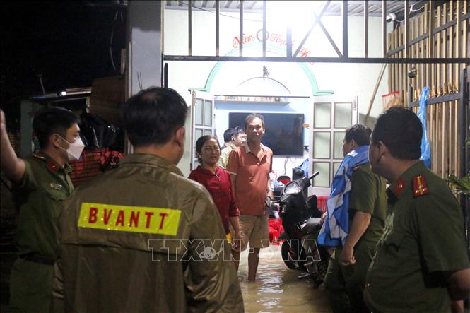 Lực lượng chức năng vận động, hỗ trợ người dân di chuyển khỏi vùng ngập sâu. Ảnh: Nguyễn Thanh - TTXVN