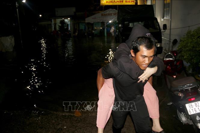 Hỗ trợ người dân di chuyển khỏi khu vực ngập sâu đến nơi an toàn. Ảnh: Nguyễn Thanh - TTXVN