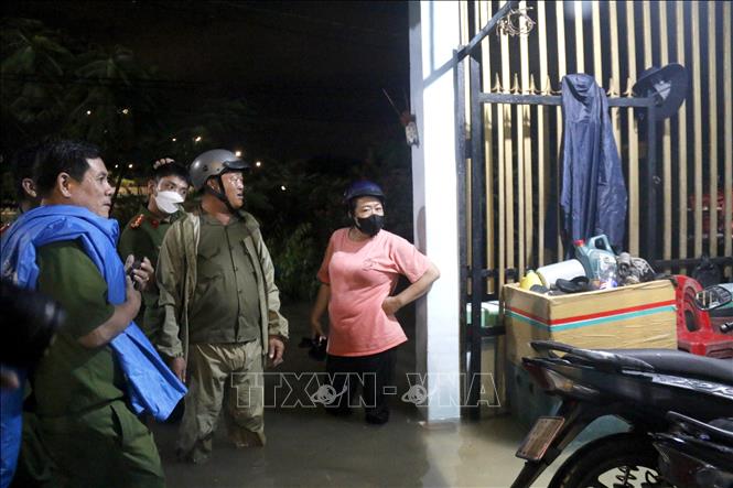 Lực lượng chức năng vận động người dân di chuyển khỏi vùng ngập sâu. Ảnh: Nguyễn Thanh - TTXVN