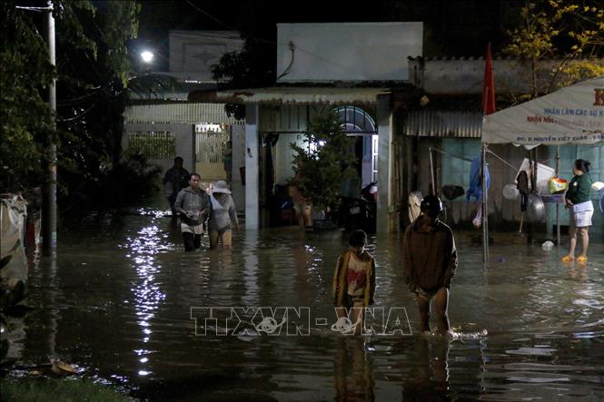 Người dân di chuyển khỏi khu vực ngập sâu đến nơi an toàn. Ảnh: Nguyễn Thanh - TTXVN