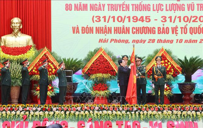 Chủ tịch nước Lương Cường gắn Huân chương Bảo vệ Tổ quốc hạng Nhất lên Quân kỳ Quyết thắng của Quân khu 3. Ảnh: Lâm Khánh - TTXVN
