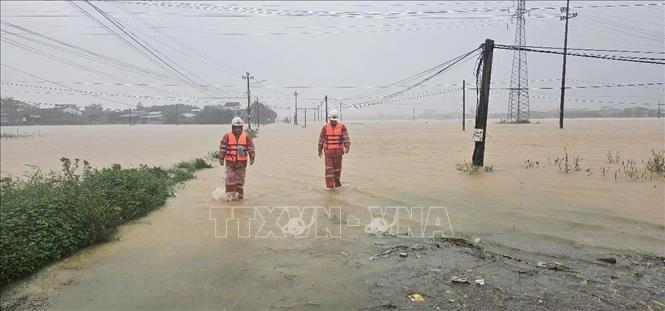 Kiểm tra đường dây tải điện tại các khu vực bị ngập nặng do mưa lũ. Ảnh: TTXVN phát 