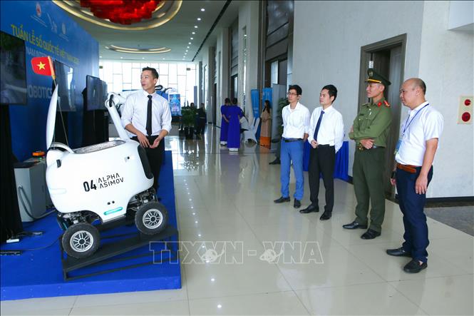 Các đại biểu tìm hiểu công nghệ robot giao hàng tự động tại Tuần lễ số Quốc tế Việt Nam 2025. Ảnh: Công Luật - TTXVN
