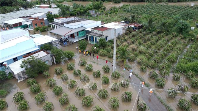 Lực lượng chức năng cùng các đoàn từ thiện viện trợ nhu yếu phẩm cho người dân ở vùng ngập lụt của phường Hàm Thắng (Lâm Đồng). Ảnh: Nguyễn Thanh - TTXVN