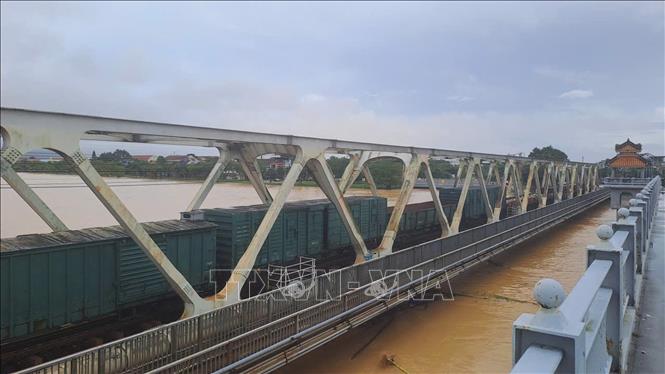 Đoàn tàu dừng trên cầu đường sắt Bạch Hổ bắc qua sông Hương để gia tải chống trôi cầu khi lũ dâng cao. Ảnh: Nguyên Lý - TTXVN