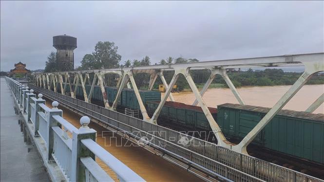 Đoàn tàu dừng trên cầu đường sắt Bạch Hổ bắc qua sông Hương, thành phố Huế để gia tải chống trôi cầu khi lũ dâng cao. Ảnh: Nguyên Lý - TTXVN