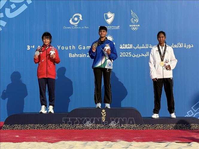 VĐV Bùi Ngọc Thảo Thơm (áo đỏ) giành huy chương bạc hạng 55kg nữ, môn Vật bãi biển tại Đại hội thể thao trẻ châu Á lần thứ 3 (AYG3) diễn ra tại Bahrain. Ảnh: TTXVN phát