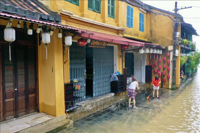 Người dân phố cổ Hội An theo con nước rút tới đâu tranh thủ dọn vệ sinh để sớm trở lại cuộc sống bình thường. Ảnh: Trần Lê Lâm - TTXVN 