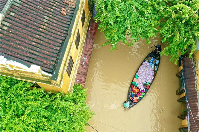 Thuyền chở thực phẩm thiết yếu cung cấp cho các hộ dân bị cô lập trong phố cổ do mưa, lũ gây ra. Ảnh: Trần Lê Lâm - TTXVN