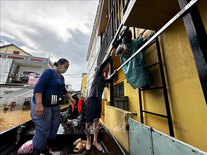 Người dân Hội An đi chợ mua thực phẩm về cho gia đình trong vùng ngập. Ảnh: Trần Lê Lâm - TTXVN