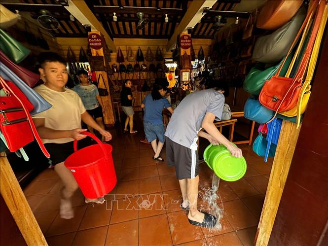 Người dân tập trung dọn của hàng để sớm trở lại kinh doanh khi nước lũ vừa rút. Ảnh: Trần Lê Lâm - TTXVN