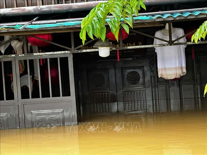 Nước lũ vượt mức báo động 3 và vượt đỉnh lũ lịch sử năm 1964 sau khi nước dần rút để lại vệt màu vàng trên chiếc áo của cửa hàng kinh doanh thời trang ở phố cổ. Ảnh: Trần Lê Lâm - TTXVN