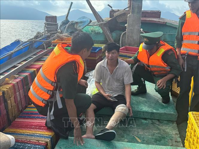 Cán bộ, chiến sĩ Đồn Biên phòng Côn Đảo thăm hỏi, chăm sóc y tế thuyền viên tàu cá BT 93839 TS. Ảnh: TTXVN phát