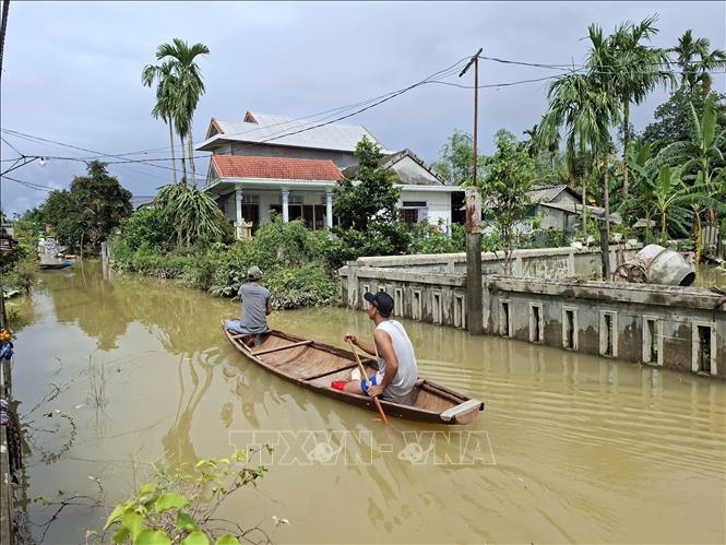 Người dân phải chèo ghe đi lại trên các con đường. Ảnh: Mai Trang - TTXVN 