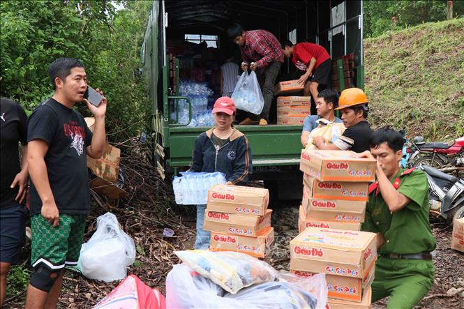 Các lực lượng tại chỗ và tình nguyện viên tham gia trung chuyển lương thực, nước uống về cho đồng bào vùng sâu vùng xa. Ảnh: Đoàn Hữu Trung - TTXVN