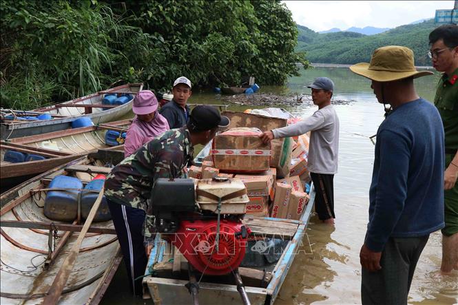 Lực lượng tại chỗ xã Trà Tân sử dụng xuồng máy vận chuyển lương thực về cho đồng bào ở khu vực còn bị cô lập với bên ngoài. Ảnh: Đoàn Hữu Trung - TTXVN
