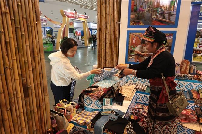Khách mua sắm hàng thổ cẩm tại gian hàng đến từ Điện Biên. Ảnh: Trần Việt - TTXVN