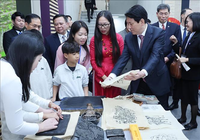 Chủ tịch nước Lương Cường thăm hỏi trẻ em người Việt Nam đang trải nghiệm làm tranh Đông Hồ tại Trung tâm Văn hoá ASEAN. Ảnh: Lâm Khánh – TTXVN