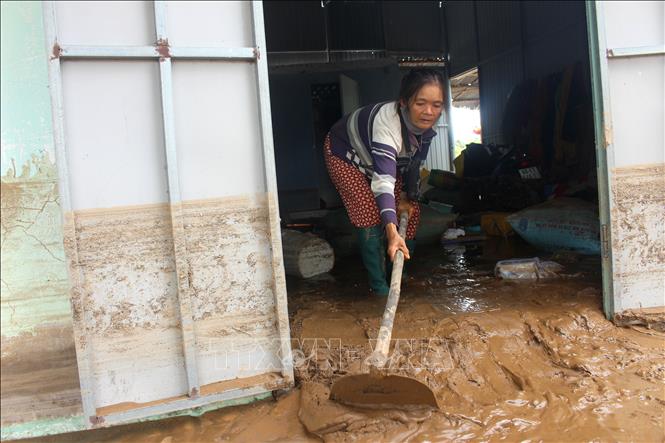 Người dân vùng bị ảnh hưởng đang dọn dẹp nhà cửa do trận lũ đêm qua. Ảnh: Hồng Hiếu - TTXVN