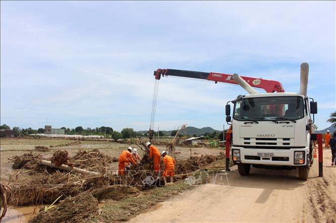 Công nhân điện lực đang khẩn trương sự cố hư hỏng đường điện do lũ. Ảnh: Hồng Hiếu - TTXVN