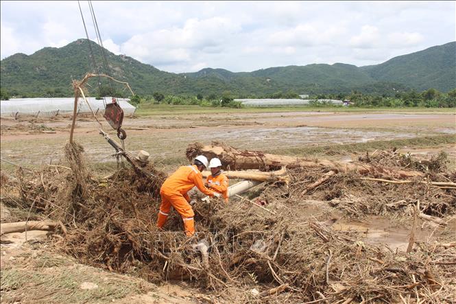 Công nhân ngành Điện lực đang khẩn trương sự cố hư hỏng đường điện do lũ. Ảnh: Hồng Hiếu - TTXVN