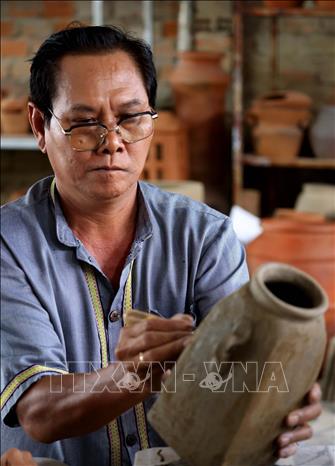 Each pattern on Bau Truc pottery is meticulously carved by skillful hands, carrying the symbols and beliefs of the Cham people. VNA Photo: Nhật Anh