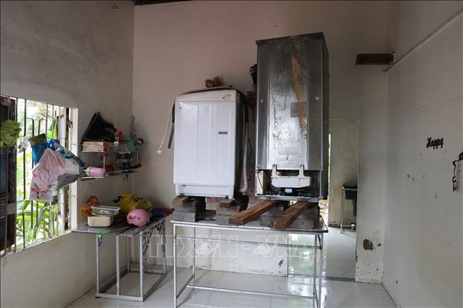 Người dân kê cao đồ đạc để “chạy” lụt lần hai. Ảnh: Anh Dũng - TTXVN