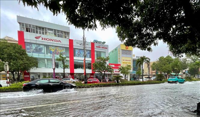 Đường Quang Trung, phường Đồng Hới, tỉnh Quảng Trị bị ngập khiến các phương tiện di chuyển khó khăn. Ảnh: Võ Dung - TTXVN 