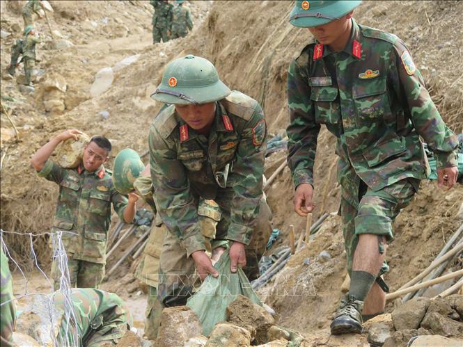 Cán bộ, chiến sĩ Quân đoàn 34 triển khai công tác mở đường vào các thôn bị cô lập do mưa lũ ở xã Ngọc Linh. Ảnh: Dư Toán – TTXVN