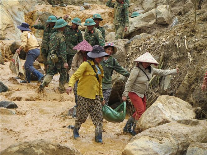 Người dân cùng các cán bộ, chiến sĩ Quân đoàn 34 triển khai công tác mở đường vào 5 thôn ở xã Ngọc Linh (Quảng Ngãi) bị cô lập do mưa lũ. Ảnh: Dư Toán – TTXVN