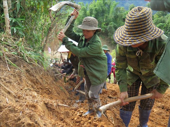 Người dân cùng các cán bộ, chiến sĩ Quân đoàn 34 triển khai công tác mở đường vào 5 thôn ở xã Ngọc Linh (Quảng Ngãi) bị cô lập do mưa lũ. Ảnh: Dư Toán – TTXVN